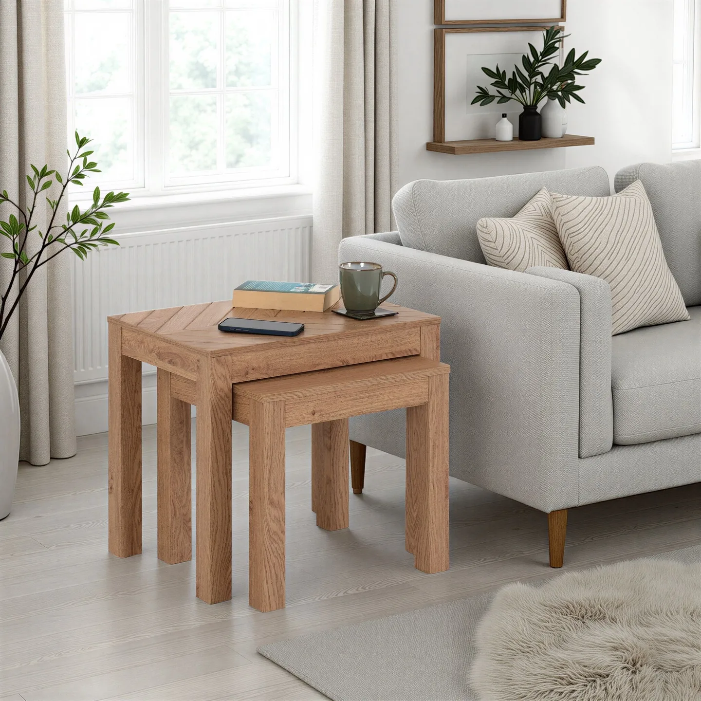 A welcoming living room with a cream sofa and Seconique Leon oak-effect nesting tables