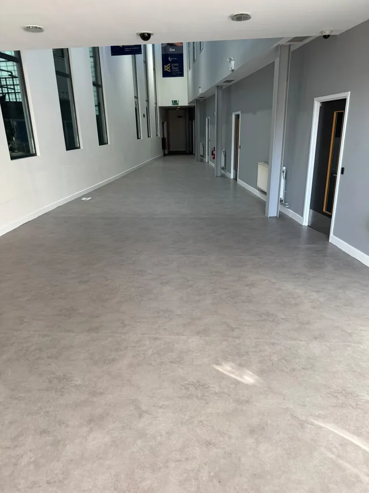 A completed grey floor in a bright shared corridor
